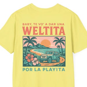 May include: Yellow t-shirt with a colorful graphic. The graphic features a beach scene with palm trees, a jeep, and the text 'BABY, TE VO' A DAR UNA WELTITA POR LA PLAYITA' in a retro style. The design includes a sunset and tropical flowers.