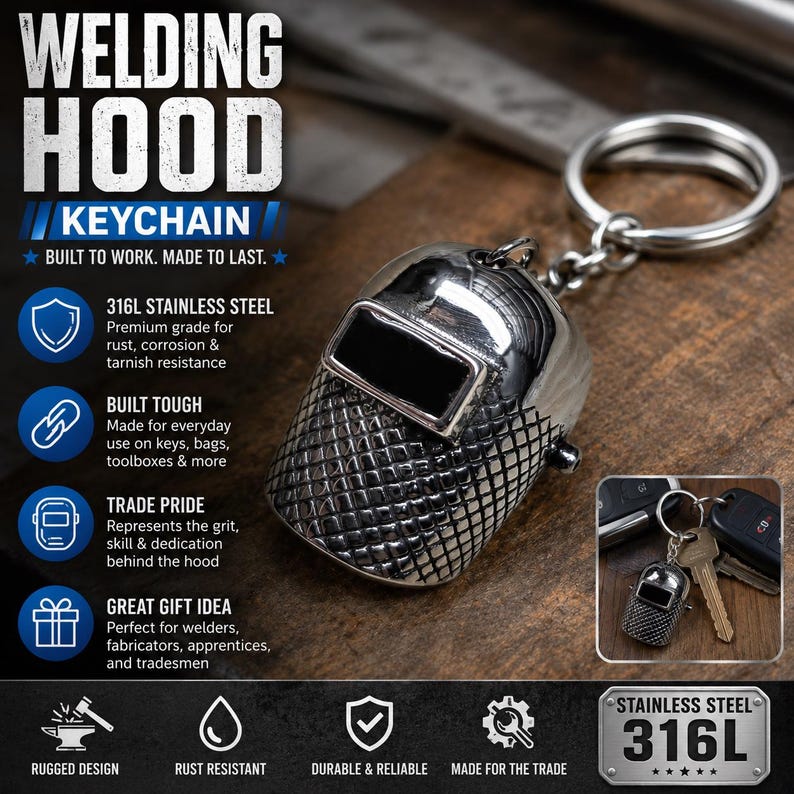 May include: A silver-toned stainless steel keychain shaped like a welding hood with a textured front surface and a black rectangular viewing window. The keychain includes a circular metal ring and is displayed with text detailing 316L stainless steel.