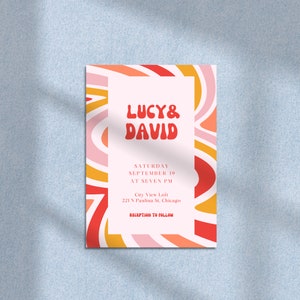 May include: A wedding invitation with a retro design featuring a pink, orange, and red swirl pattern. The invitation reads "Lucy & David" in a bold, red font. The date and time of the wedding are listed as "Saturday, September 19, at Seven PM". The location is listed as "City View Loft, 221 N Paulina St, Chicago". The invitation concludes with "Reception to Follow".