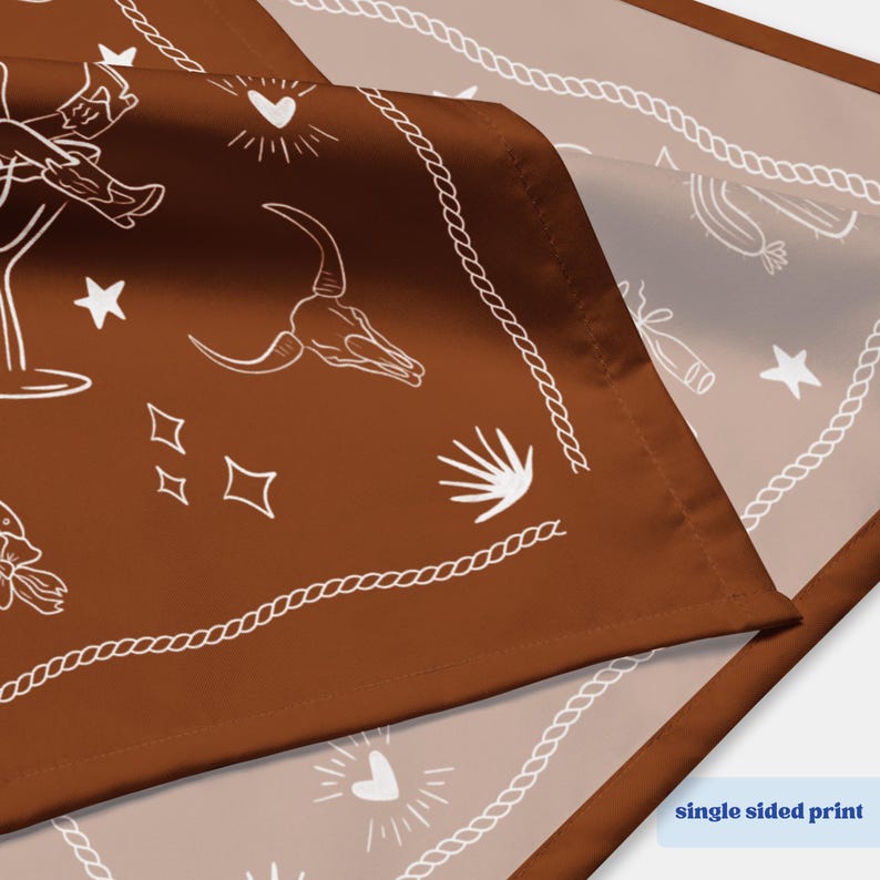 May include: A brown bandana with a white rope border and various white illustrations, including a steer skull, cowboy boots, and stars. The bandana has a single-sided print.