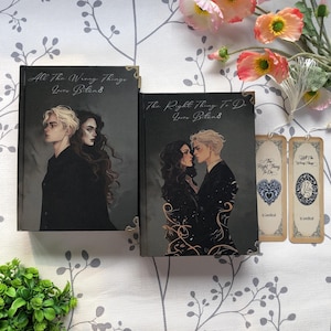 May include: Two hardcover books and two bookmarks. The books have dark covers with illustrations of a man and woman. The text on the books reads "All The Wrong Things" and "The Right Thing To Do". The bookmarks have similar designs.