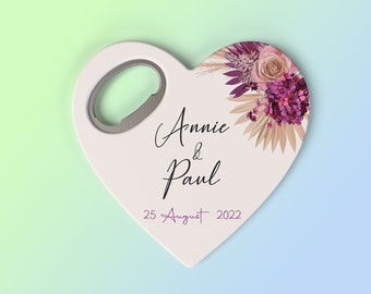 May include: White heart-shaped bottle opener with a floral design in shades of pink, purple, and beige. The text "Annie & Paul 25 August 2022" is printed on the opener.