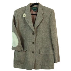 May include: A brown tweed blazer with a notched lapel, three-button closure, and two front pockets. The blazer features light green suede elbow patches and a small decorative pin. The label reads "Lauren Ralph Lauren."