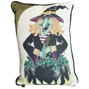 May include: Rectangular decorative pillow featuring a cartoon witch with green skin, orange hair, and a black hat. The witch is holding a wooden stick over a bubbling cauldron. The pillow has a black border and is perfect for Halloween.