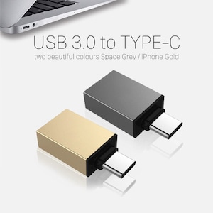 Puede incluir: Dos adaptadores USB 3.0 a Tipo-C, uno dorado y otro gris espacial, se muestran sobre un fondo blanco. Los adaptadores tienen forma rectangular con un conector Tipo-C. El texto "USB 3.0 to TYPE-C" es visible.