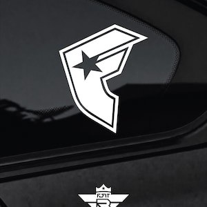 May include: A white vinyl decal featuring the stylized letter F with a star integrated into the top bar, applied to a dark glass surface. Below the main decal is a smaller white emblem featuring a crown, the letters FORT, and a shield design.
