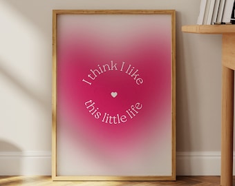 May include: A framed print with a pink gradient background and white text that reads "I think I like this little life" with a small heart symbol.