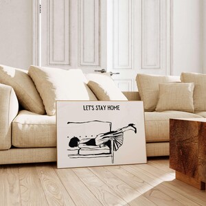 May include: Black and white illustration of a person lying upside down on a couch with the text "Let's Stay Home".