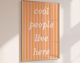 May include: A framed print with orange and pink stripes and the text "cool people live here" in white.