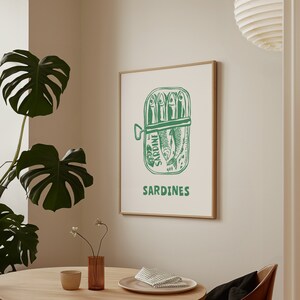 May include: A green and white illustration of a sardine can with the word "SARDINE" printed on the can. The can is filled with sardines and the text "SARDINES" is printed below the can.