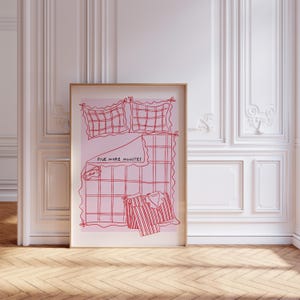 Puede incluir: Una ilustraci&oacute;n rosa y roja de una cama con un patr&oacute;n a cuadros. El texto "Five More Minutes" est&aacute; escrito en la manta. Un pijama y una m&aacute;scara para los ojos est&aacute;n en la cama.