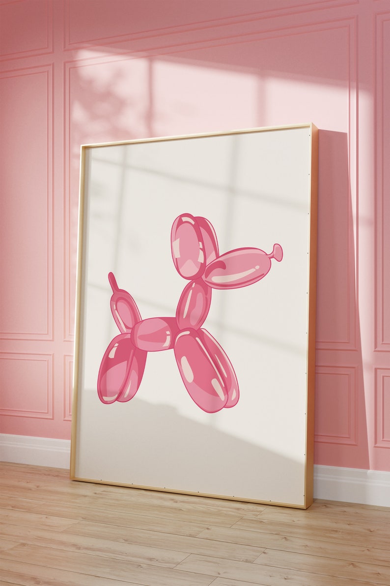 Puede incluir: Un animal de globo rosa con forma de perro, en un marco dorado, contra una pared rosa.