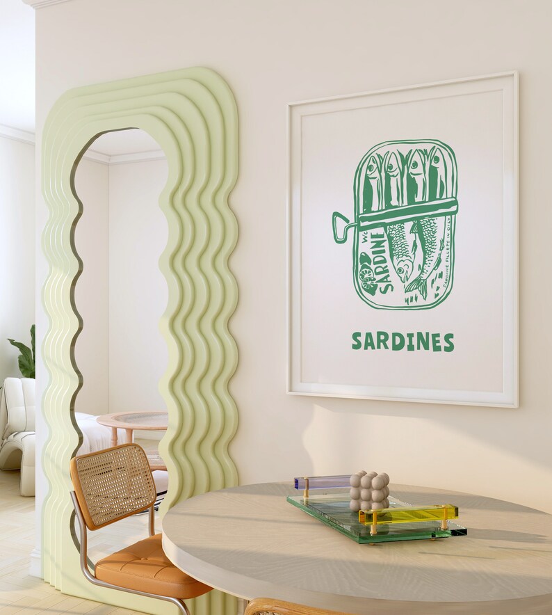 May include: A white framed print with a green illustration of a can of sardines. The can has the word "SARDINE" printed on it and the text "SARDINES" is printed below the can.