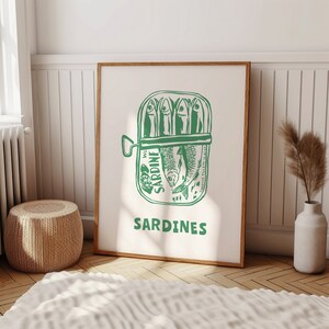 May include: A green and white illustration of a can of sardines with the text "SARDINES" printed below. The can has the words "WC SARDINE" printed on the side.