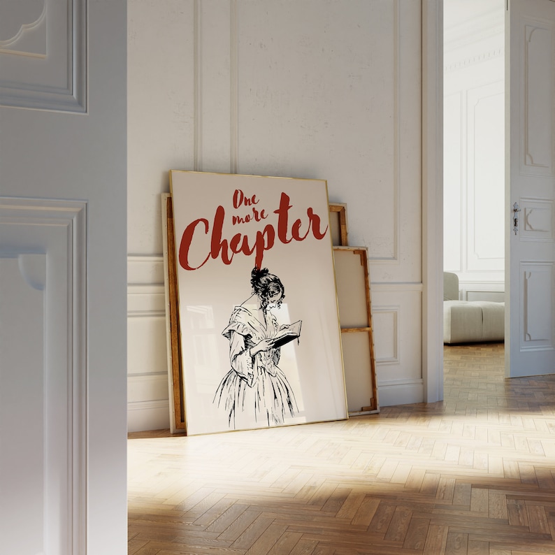 May include: A framed print with a black and white illustration of a woman reading a book. The text "One more Chapter" is written in red cursive letters.