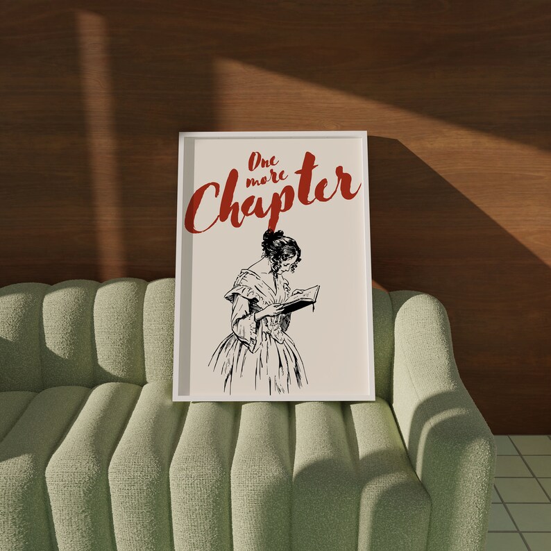 May include: A white framed print with a black and white illustration of a woman reading a book. The text "One more Chapter" is in red letters.