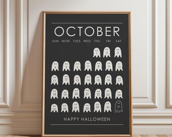 May include: A framed wall art print featuring a black October calendar with white text and ghost-shaped icons for each day. The calendar displays the days of the week, numbers one through thirty-one inside the ghosts, and the text Happy Halloween.