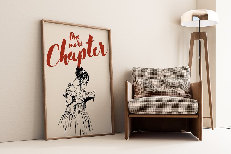 May include: A framed print with a black and white illustration of a woman reading a book. The text "One more Chapter" is written in red cursive lettering.