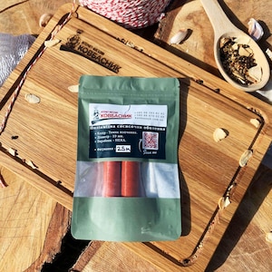 Può includere: Una busta di plastica verde contenente budello per salsicce rosso, etichettata con il testo "Поліамідна сосисочна оболонка", "Колір - Темне копчення", "Діаметр - 19 мм", "Виробник - НЕКА" e "Фасування - 25м", con un codice QR e contatti.