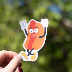 Hotdog character holding up peace signs sticker