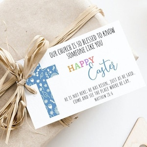 May include: A wrapped gift tied with raffia, featuring a white card with a blue floral cross. The card reads "OUR CHURCH IS SO BLESSED TO KNOW SOMEONE LIKE YOU" and "HAPPY Easter". Includes a Bible verse from Matthew 21:6.