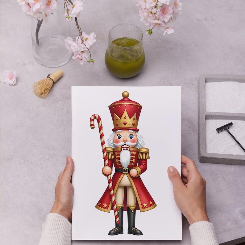 Może przedstawiać: Kolorowa ilustracja żołnierza dziadka do orzech&oacute;w w czerwonym i złotym mundurze, trzymającego laskę cukrową. Dziadek do orzech&oacute;w ma białą brodę i koronę. Obraz jest na białym tle.