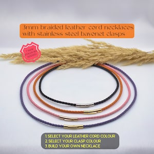 May include: Five braided leather cord necklaces with stainless steel bayonet clasps. The necklaces are in purple, pink, orange, brown, and black. The text on the image reads: "3mm braided leather cord necklaces with stainless steel bayonet clasps. 7 NEW COLOURS ADDED. 1. SELECT YOUR LEATHER CORD COLOUR 2. SELECT YOUR CLASP COLOUR 3. BUILD YOUR OWN NECKLACE"