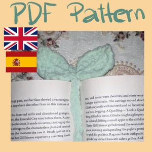 Puede incluir: Un marcapáginas hecho a mano, de color verde claro, con forma de lazo, colocado en un libro abierto. El texto "PDF Pattern" está en la parte superior de la imagen. Las páginas del libro son visibles, con texto impreso.