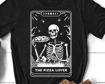 May include: Black t-shirt with a white graphic of a skeleton holding a pizza slice. The graphic is in the style of a tarot card and reads "The Pizza Lover".
