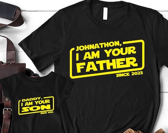 May include: Black t-shirts with yellow text that reads "Daddy, I am your son since 2023" and "Johnathon, I am your father since 2023".