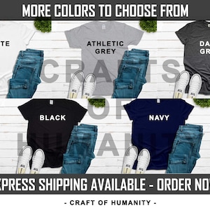 May include: Six t-shirts laid out on a white wood surface, showing different colour options. The colours are white, athletic grey, dark grey, black, navy, and a light blue. The text "MORE COLORS TO CHOOSE FROM" is at the top of the image. The text "CRAFT OF HUMANITY" is at the bottom of the image.