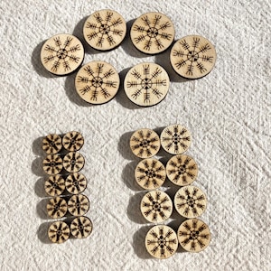 Puede incluir: Un conjunto de discos redondos de madera con un diseño geométrico en blanco y negro. Los discos están dispuestos en forma del número 17.