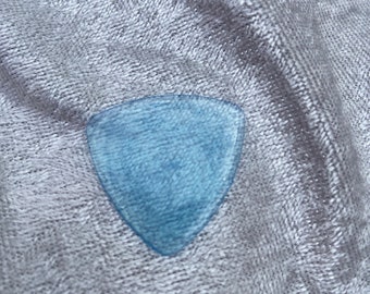 May include: A light blue guitar pick with a textured surface.