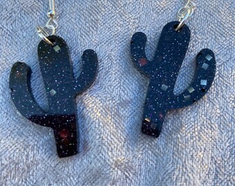 May include: A pair of black glitter cactus earrings with silver hooks.