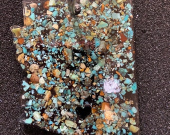 May include: A turquoise and brown resin keychain shaped like the state of Arizona with a small heart cutout.