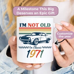 May include: White ceramic mug with the text "I'M NOT OLD" in red and a classic car graphic. The mug also features the year "1971" in multiple colours. The mug has the text "I'm Classic" and "A Milestone This Big Deserves an Epic Gift".