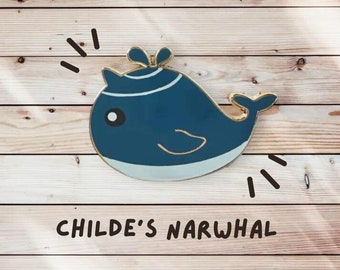 Op de afbeelding: Een blauwe en witte emaille pin van een narwal met een gouden rand. De pin heeft een speels ontwerp en staat onderaan "Childe's Narwhal".