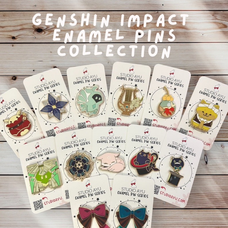 May include: A collection of 12 enamel pins featuring characters and items from the video game Genshin Impact. The pins are on white cards with the text "Studio Ayu Enamel Pin Series".