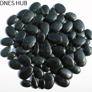 May include: A large group of dark green, oval-shaped, sparkly stones. The stones have a glittery, speckled appearance.
