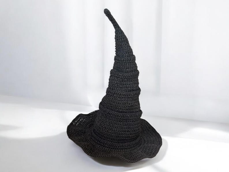 May include: A black crocheted witch hat with a tall, pointed crown and a wide brim.