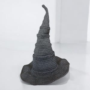 May include: A gray crocheted witch hat with a tall, pointed crown and a wide brim.