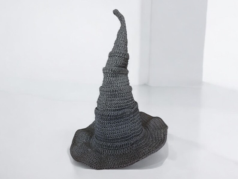 May include: A gray crocheted witch hat with a tall, pointed crown and a wide brim.