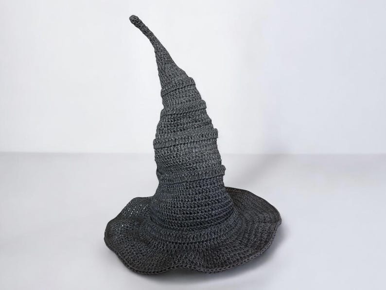 May include: A gray crocheted witch hat with a tall, pointed crown and a wide brim.
