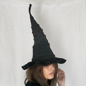 May include: A black crocheted witch hat with a tall, pointed crown and a wide brim.