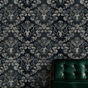 Può includere: Carta da parati damascata blu scuro e grigia con un aspetto vintage invecchiato. Il motivo presenta disegni floreali e a volute ornati. Un divano in pelle verde con struttura in legno è in primo piano.