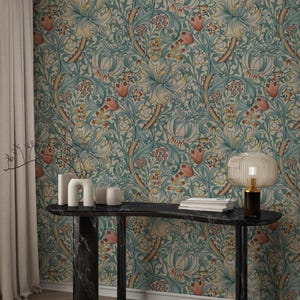 Może przedstawiać: Pokój z czarnym marmurowym stołem konsolowym, dekoracyjną lampą i wazonami. Tapeta ma kwiatowy wzór w kolorze morskim, żółtym i pomarańczowym. Po lewej stronie znajduje się beżowa zasłona.