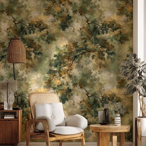 Pode incluir: Um quarto com papel de parede com tema da natureza apresentando galhos e folhas de árvores em estilo aquarela, em tons de verde, marrom e amarelo. O quarto inclui uma cadeira de madeira, mesa lateral e uma lâmpada tecida.