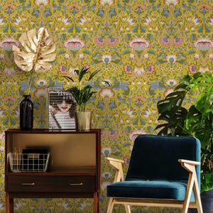 Puede incluir: Una taza de cerámica blanca con asa negra y el texto "But First, Coffee" en negrita negra. La taza se encuentra sobre un fondo borroso, sugiriendo un ambiente acogedor.