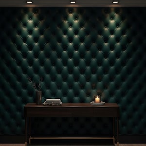 May include: A dark green tufted wall serves as a backdrop for a dark wood console table. The table holds a vase with dried stems, a stack of books, and a lit candle on a small plate. Overhead, three recessed lights illuminate the scene.