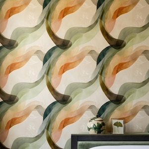 Pode incluir: Papel de parede com um padrão repetitivo de pinceladas onduladas, sobrepostas e translúcidas em tons de verde floresta, verde sálvia e laranja queimado sobre um fundo creme, com um pote de cerâmica e uma moldura com folha de ginkgo.